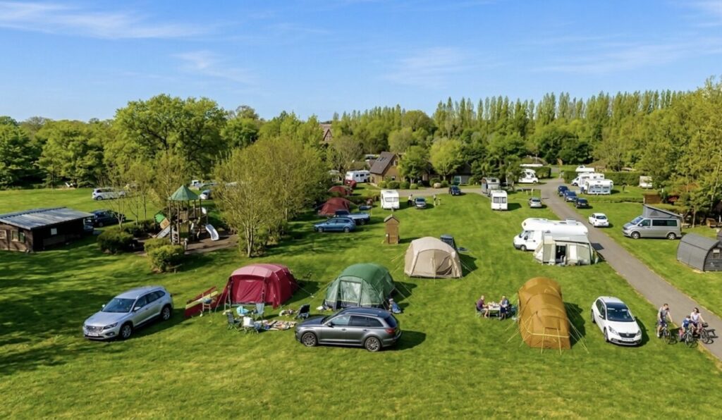a campsite with tents and touring caravans and cars